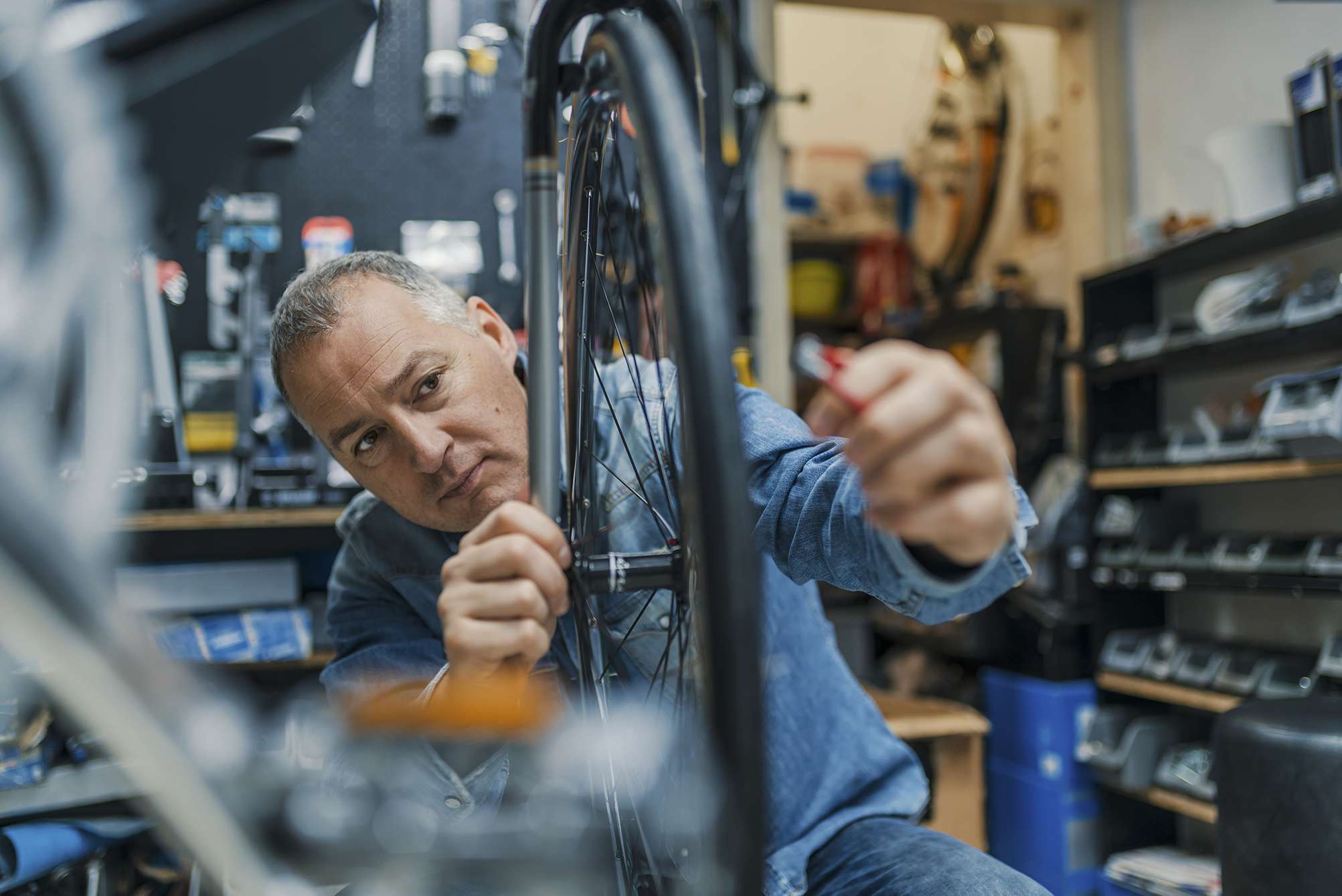 Technical expertise taking care Bicycle Shop. Repair technician bicycles was repaired gear bike shop. Friendly and competent bicycle mechanic in a workshop repairs a bike